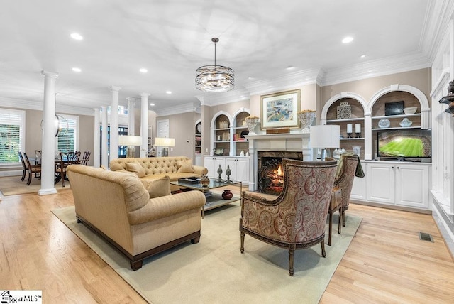 1212 Stillwater Dr, Seneca, SC 29678 - living area featuring built in shelves, decorative columns, visible vents, light wood-style flooring, and a high end fireplace