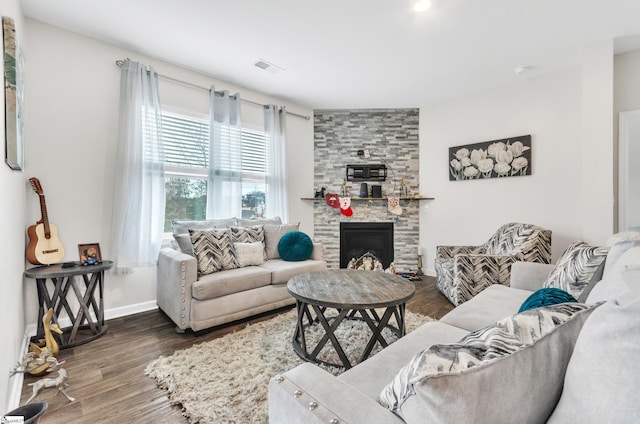 living area featuring a fireplace, baseboards, and wood finished floors