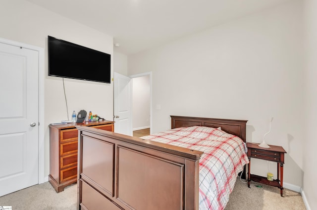 bedroom with light colored carpet and baseboards