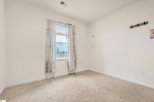 empty room with carpet, visible vents, and baseboards