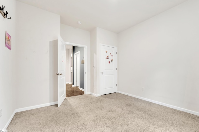 carpeted empty room featuring baseboards