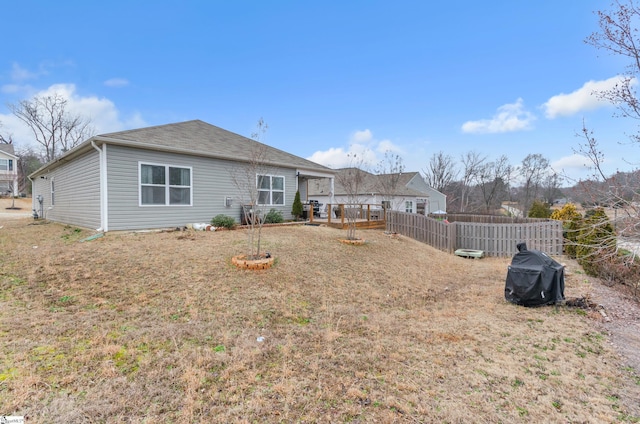 back of property with fence and a wooden deck