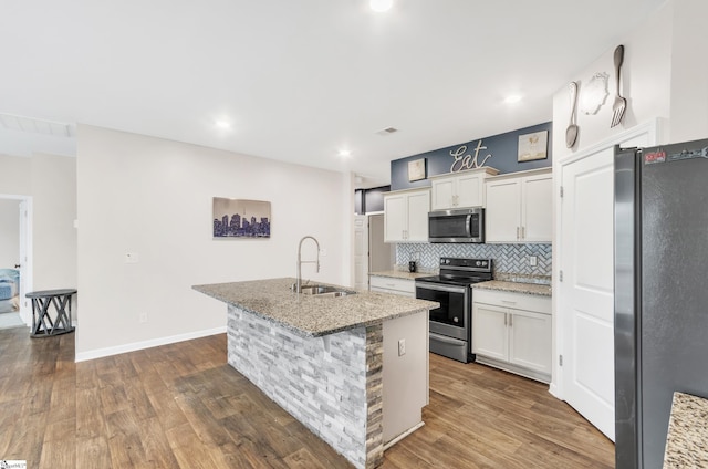 kitchen with stainless steel appliances, backsplash, a sink, and white cabinets