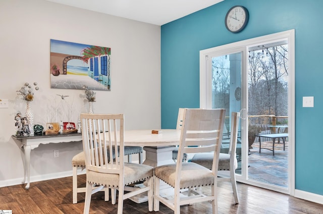 dining space featuring wood finished floors and baseboards