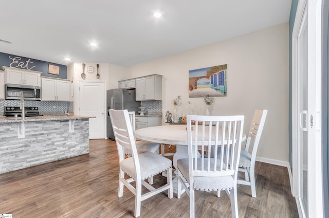 dining area featuring visible vents, baseboards, and wood finished floors