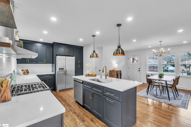 kitchen featuring light countertops, appliances with stainless steel finishes, a sink, and light wood-style flooring