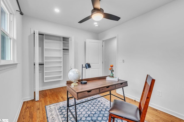 office area with ceiling fan, a healthy amount of sunlight, light wood-style flooring, and baseboards