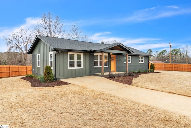 ranch-style house with brick siding, fence, board and batten siding, and roof with shingles