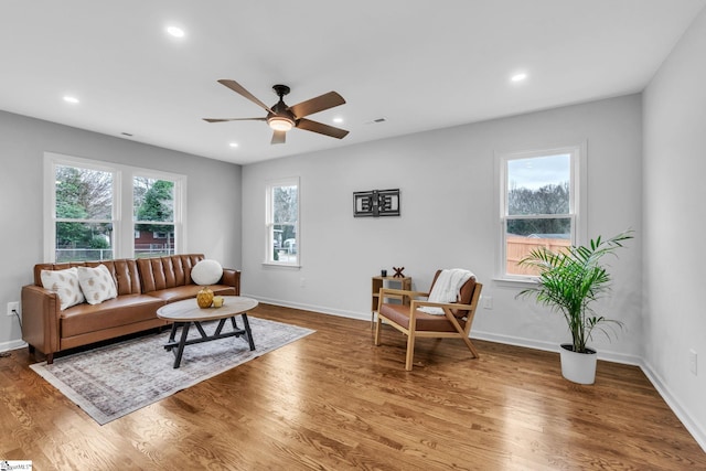 living area with recessed lighting, wood finished floors, and a healthy amount of sunlight