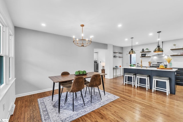 dining room with recessed lighting, baseboards, a notable chandelier, and light wood finished floors