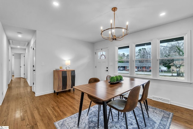 dining room with attic access, visible vents, baseboards, and wood finished floors