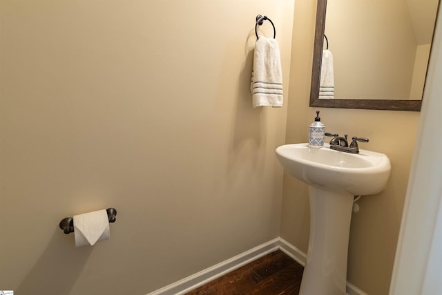 bathroom featuring a sink, baseboards, and wood finished floors