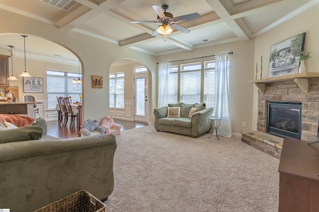 carpeted living area with beamed ceiling, a fireplace, coffered ceiling, and visible vents