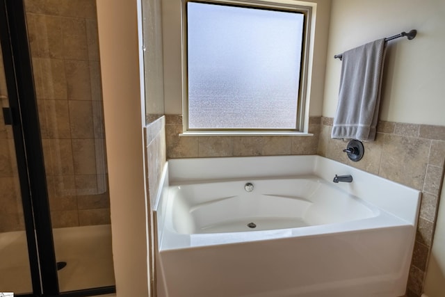 full bathroom featuring a garden tub and a stall shower