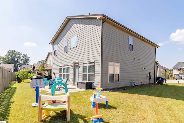 rear view of house with a lawn, a patio area, and fence