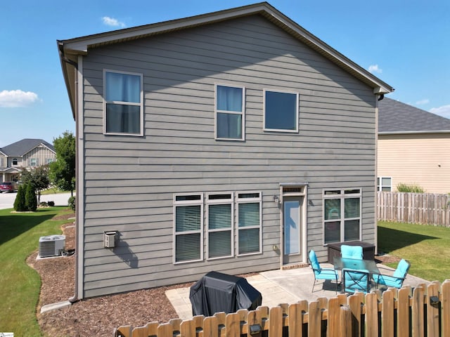 back of house with fence, a lawn, cooling unit, and a patio