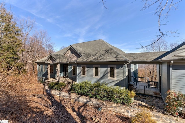 view of side of property with roof with shingles