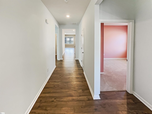 hallway featuring dark wood-style flooring, recessed lighting, visible vents, and baseboards