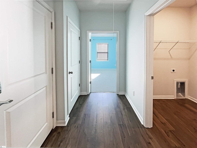 hallway featuring dark wood finished floors, attic access, and baseboards