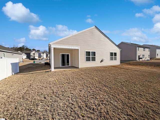 rear view of property with a residential view and fence