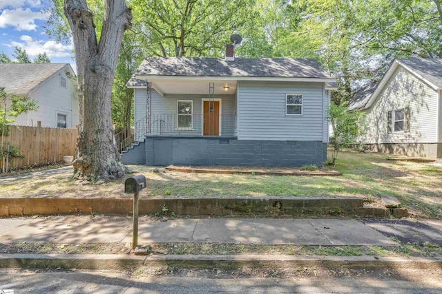 bungalow-style house with covered porch, a chimney, and fence