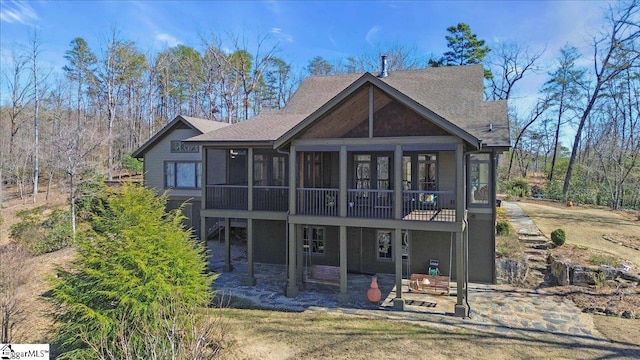 back of property with a patio area, stairway, and a sunroom