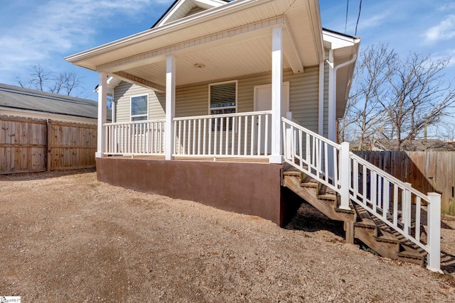 exterior space featuring covered porch and fence