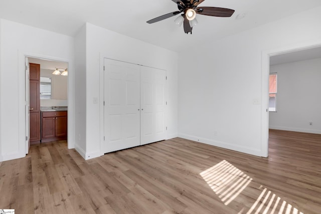 unfurnished bedroom featuring baseboards, ceiling fan, a closet, and light wood-style floors