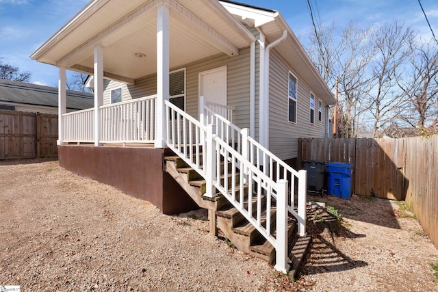 view of property exterior with fence and a porch