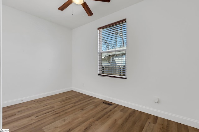 empty room featuring visible vents, baseboards, and wood finished floors