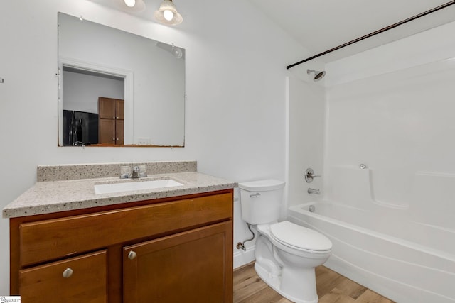 bathroom with tub / shower combination, vanity, toilet, and wood finished floors