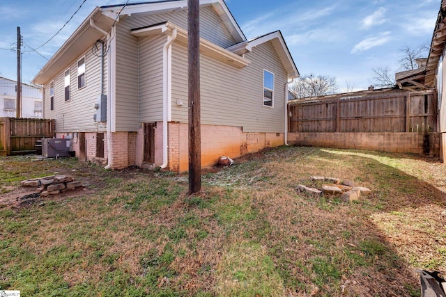 view of home's exterior featuring fence and a lawn