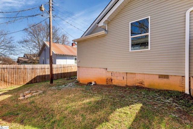 view of property exterior with crawl space, fence, and a lawn