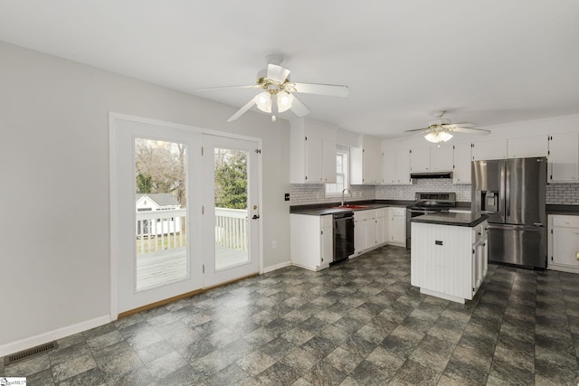 kitchen featuring tasteful backsplash, visible vents, dark countertops, appliances with stainless steel finishes, and a sink