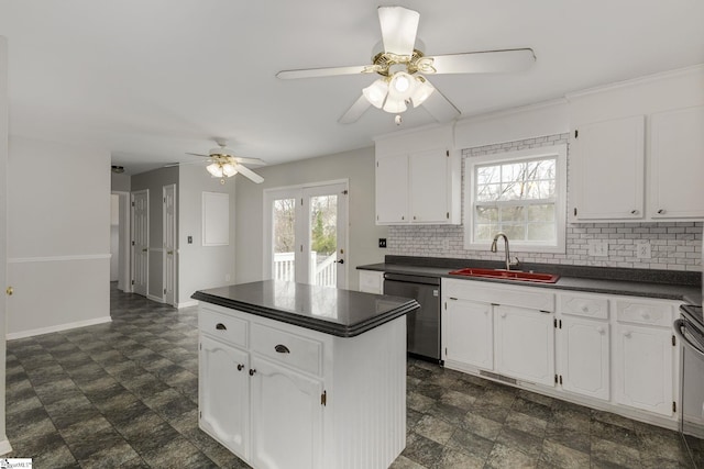 kitchen featuring dark countertops, white cabinets, a sink, and stainless steel dishwasher