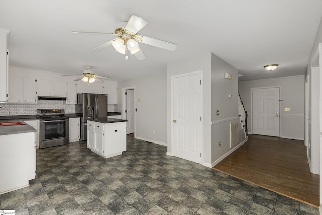 kitchen featuring dark countertops, under cabinet range hood, white cabinets, and stainless steel appliances