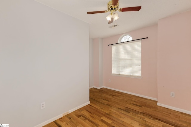 spare room featuring visible vents, ceiling fan, baseboards, and wood finished floors