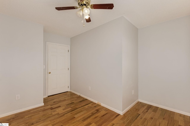 empty room featuring baseboards, ceiling fan, and light wood finished floors