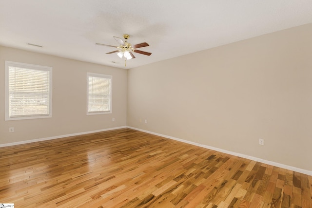 unfurnished room featuring a ceiling fan, light wood-style flooring, and baseboards