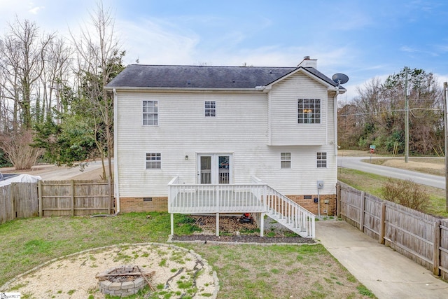 rear view of property with an outdoor fire pit, fence, crawl space, a lawn, and a chimney