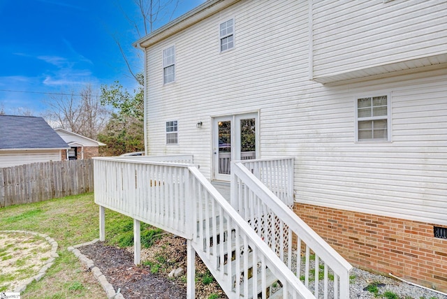 view of exterior entry with fence and a wooden deck