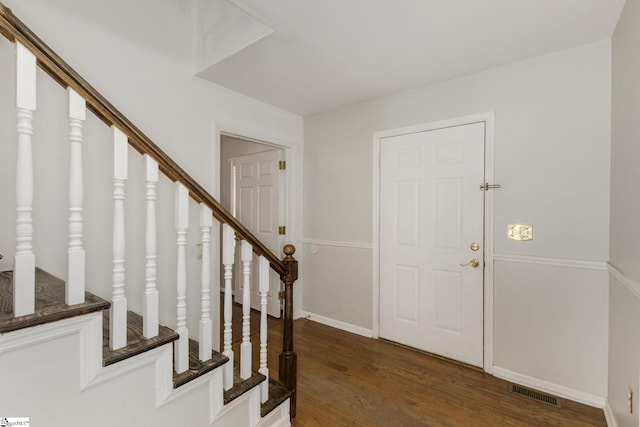 foyer entrance featuring stairway, wood finished floors, visible vents, and baseboards