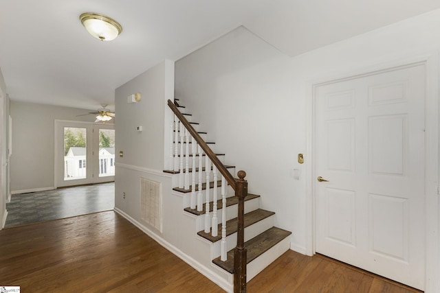 stairway featuring visible vents, baseboards, and wood finished floors