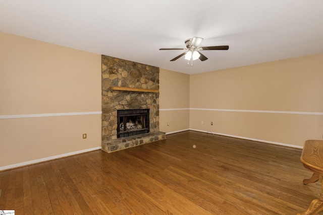 unfurnished living room featuring a ceiling fan, a fireplace, baseboards, and wood finished floors