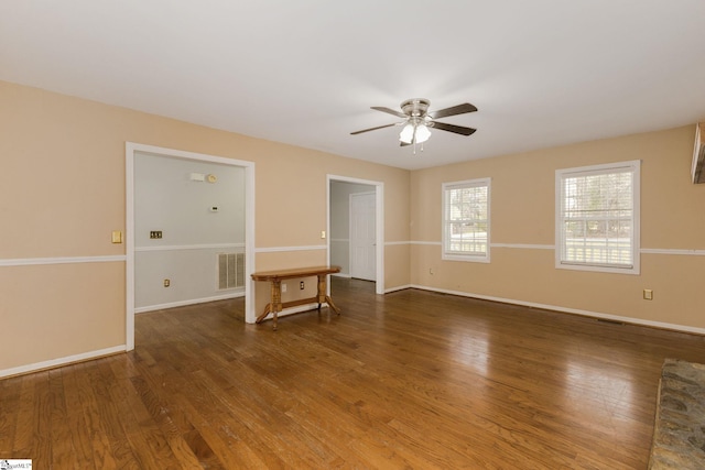 spare room featuring ceiling fan, wood finished floors, visible vents, and baseboards