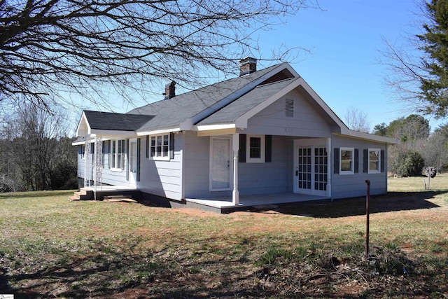 view of property exterior with roof with shingles, a lawn, and a chimney