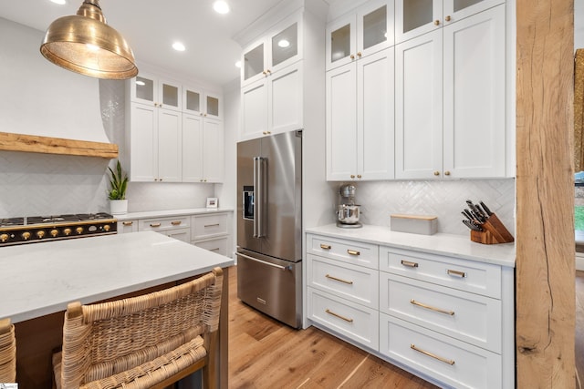 kitchen featuring high quality fridge, light wood-style flooring, white cabinetry, and decorative backsplash