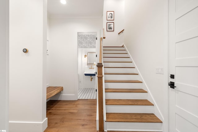 staircase with recessed lighting, crown molding, baseboards, and wood finished floors