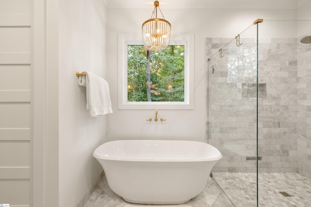 full bathroom featuring a freestanding bath, marble finish floor, a stall shower, and an inviting chandelier