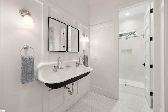 full bath featuring a stall shower, a sink, and tile patterned floors